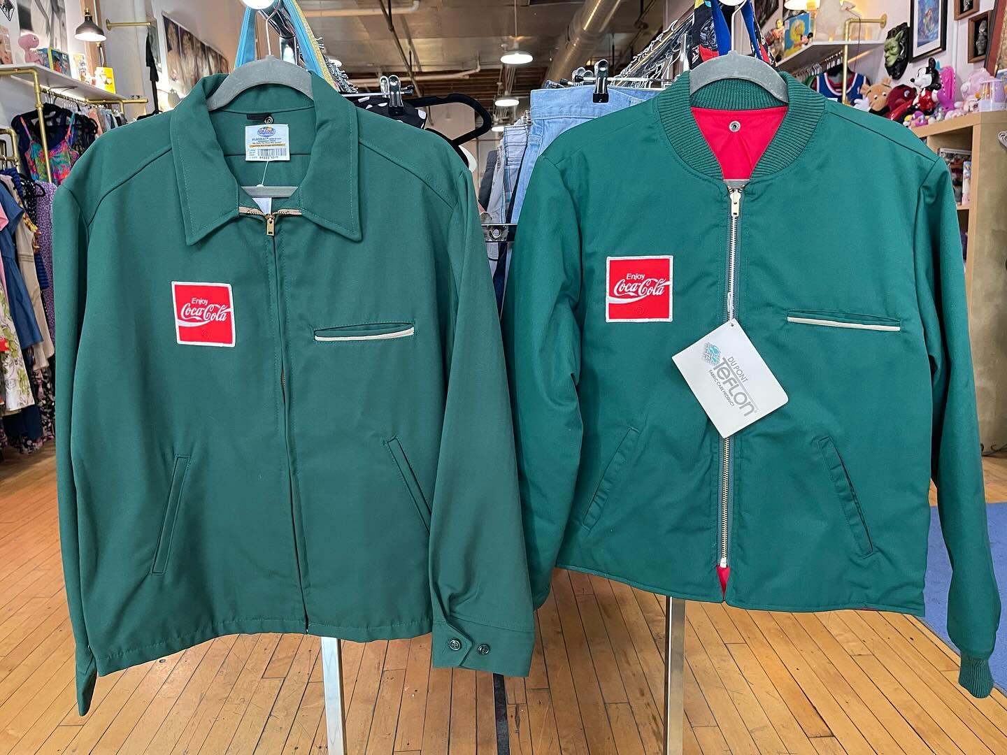 Vintage Coca-Cola green work jackets on hangers